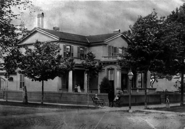 View from street towards the J.H. Kelley house. The home was located at the Northwest corner of Wisconsin Avenue and 8th Street, which is now the Southeast corner of the block containing the present Racine County Court House. James H. Kelley - Died 1905 at his residence. He was the President of The Racine Silver Plate Company, manufacturers of gold and silver plated ware, Britannia ware, cutlery, etc. Their goods were classed with those of Rogers & Co., and other well known Eastern manufacturers. He also owned Kelley, Weeks & Co. 927 N. Erie Street. Wholesale Lumber Dealer.