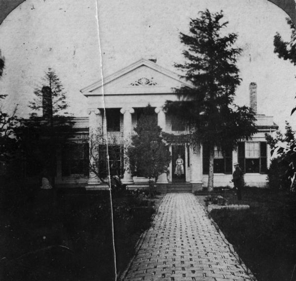 Exterior view of the William H. Lathrop residence, with a figure standing in the front entranceway.
