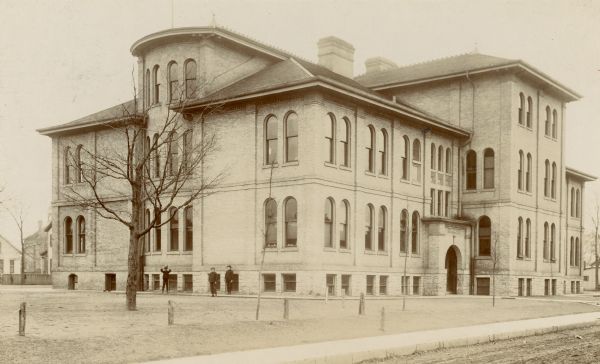 Exterior view of the Franklin School. Children are standing along the side of the building.