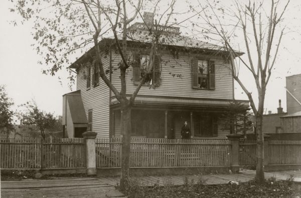 The Lewis Dickinson residence on the south side of State St. between LaSelle and Marquette Streets, the later site of Daniel Hall. Mrs. Dickinson is on the porch, and George Harris is in the upper window at the left.