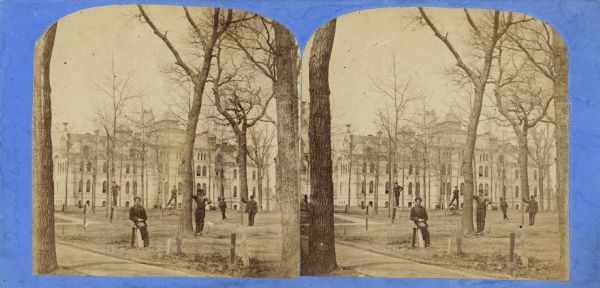 Stereograph of Taylor Hall on the Racine College campus with multiple individuals standing on its front lawn.
