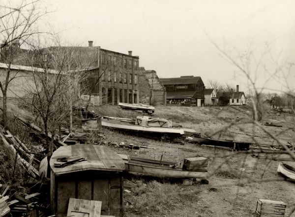 View of multiple old warehouses on the levee. Boats are pulled up on the slope in the foreground.