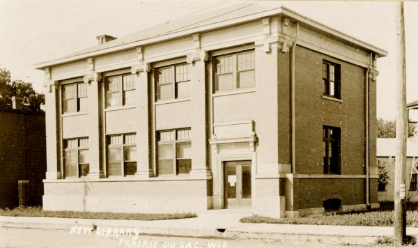 View from street of the Tripp Memorial Library in Prairie du Sac, Wisconsin, about 1912. Caption reads: "New Library, Prairie du Sac, Wis."