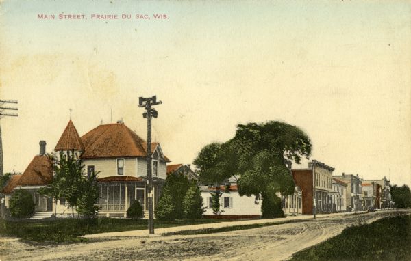 View from right side of street towards a house and retail stores lining the left side of Main Street. Caption reads: "Main Street, Prairie Du Sac, Wis."
