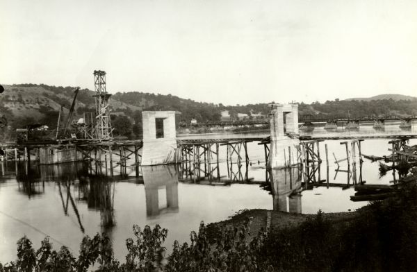 View from shoreline of toll bridge under construction.
