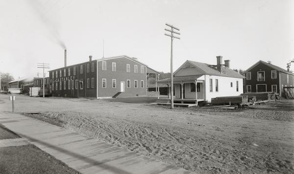 F.G. and C.A. Stanley Manufacturing Plant. There is a plank sidewalk in the foreground.