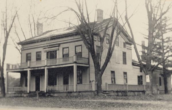 Exterior view of Hawks tavern, also known as Hawks Inn, with a porch and deck in the front.