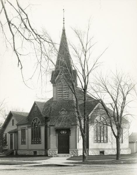 Congregational Church at the corner of Broadway and Cass Street, with the entrance at the corner. The church has stained glass windows and a steeple.