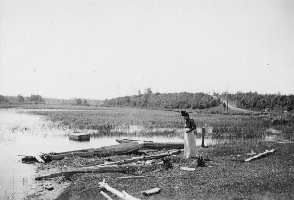 A woman stands in a marsh near the site of Eleazer William's first house.