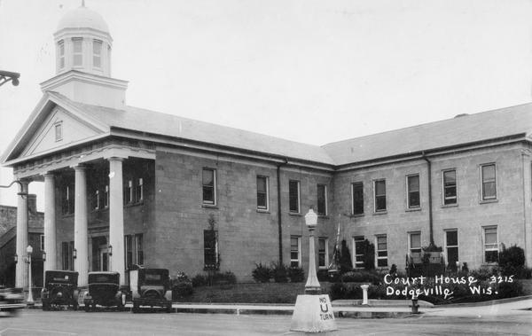 Exterior view of the Iowa County Court House, with cars parked at the curb in front.