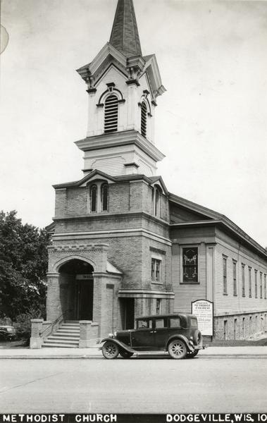 Exterior view of the Dodgeville Methodist Church, with a car parked in front.