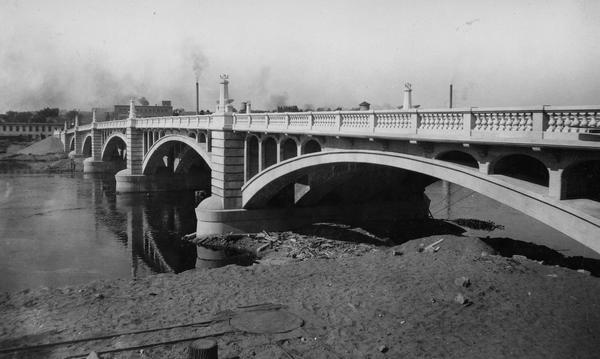 Madison Street Bridge, built in about 1925. View from shoreline across river with the bridge on the right.