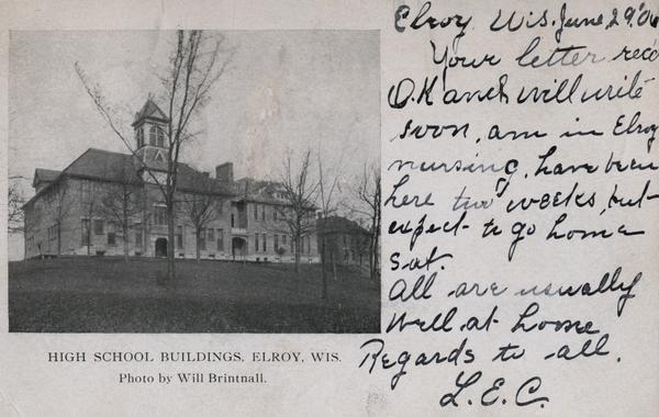 Exterior view of high school buildings with trees. Caption reads: "High School Buildings, Elroy, Wis."
