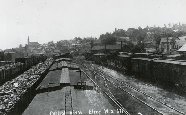 Elevated view above railroad cars towards downtown Elroy. Caption reads: "Partial View Elroy Wis."