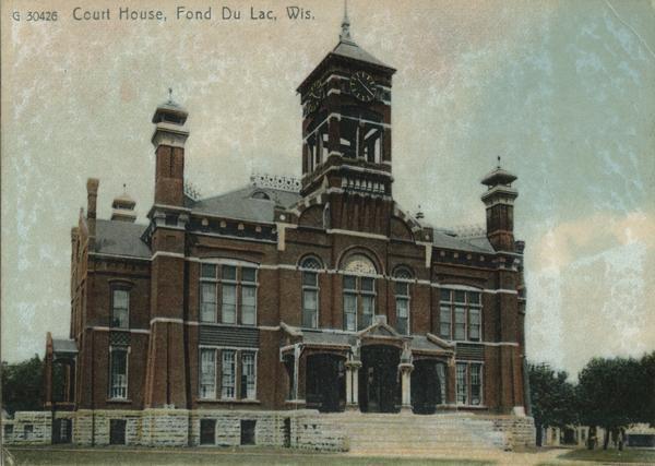 Exterior, colorized view of the County Courthouse. The courthouse is at least two stories, with wide steps leading up to the front entrance framed with columns. A clock tower is above the entrance to the building. Caption reads: "Court House, Fond Du Lac, Wis."