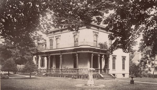 View of exterior of the Caswell residence, with a fountain and trees. Home of Chester S. Caswell, 303 Mechants Avenue.
