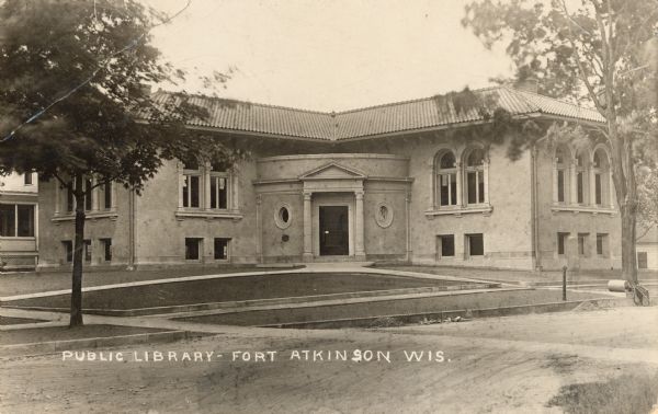 View across street towards the front entrance to the library. Caption reads: "Public Library — Fort Atkinson Wis."