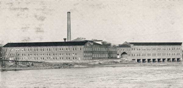 View of river and the building's exterior.  This building is where  Consolidated Water Power and Paper company operates its business.  The building's facade faces the river.