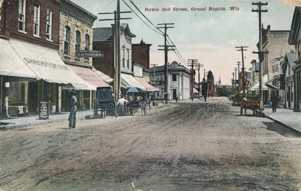 View looking down Second Street with people, horse-drawn vehicles and storefronts and signs lining the street. Caption reads: "Down 2nd Street, Grand Rapids, Wis".