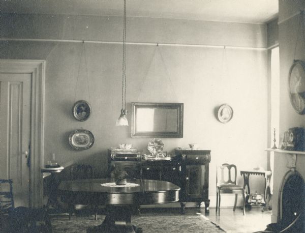 Interior view of the dining room, with a fern plant on top of the dining room table.