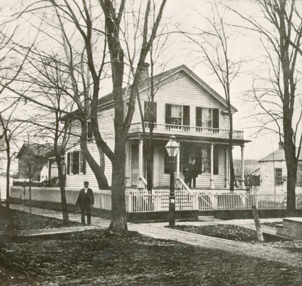 Exterior of the Chapman residence, at the corner of Walnut and Adams Streets. A man is standing on the sidewalk in front.