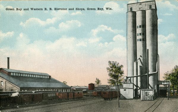 Green Bay and Western Railroad elevator, shops, and railroad tracks with trains.