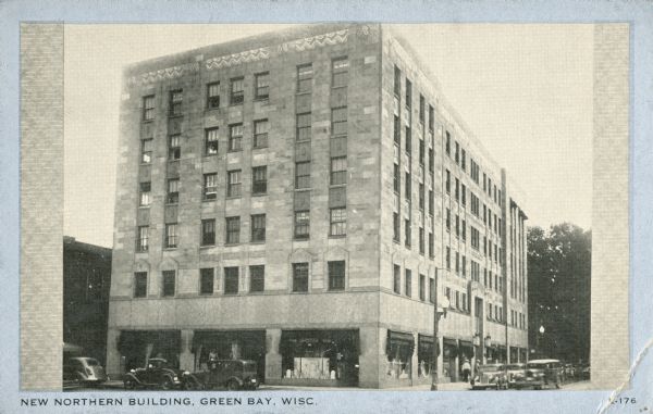Exterior view across street towards the Northern Building, with cars parked along the curb near lampposts. Caption reads: "New Northern Building, Green Bay, Wisc."