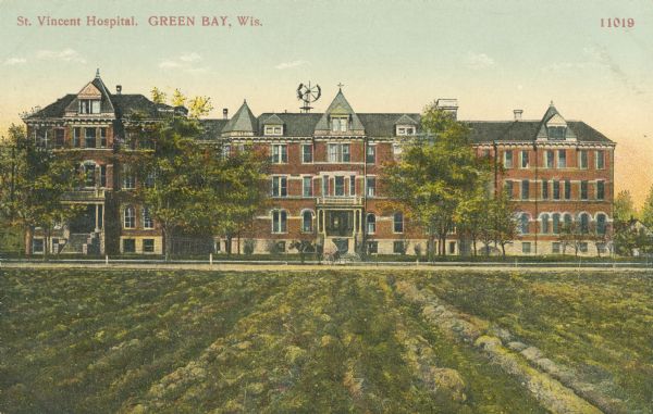 View across field toward the hospital. Caption reads: "St. Vincent Hospital, Green Bay, Wis."