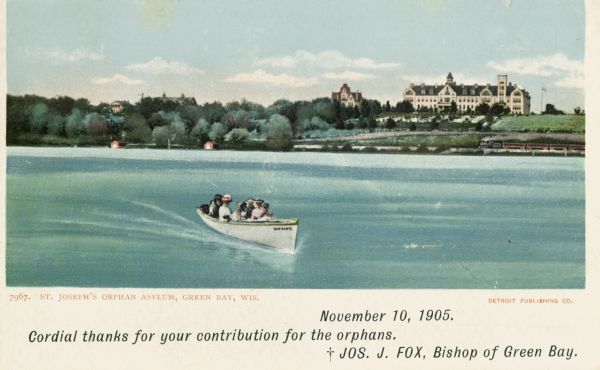 A group of people are in a motorboat, named "Quo Vadis,, in the lake in front of St. Joseph's orphan asylum. Caption reads: "St. Joseph's Orphan Asylum, Green Bay, Wis." Additional printed text reads: "November 19, 1905. Cordial thanks for your contribution for the orphans. Jos. J. Fox, Bishop of Green Bay."