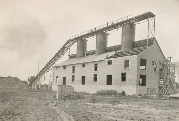 A construction crew at work on the Western Lime and Cement company's factory, which is located between McDonald Street and the west bank of the Fox River.