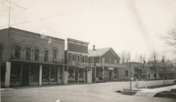 View from intersection of commercial buildings along the left side of a street.