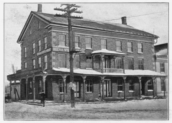 View of the Buena Vista House with electric power lines. This Greek revival inn was erected in 1843 by Samuel R. Bradley of Milwaukee, who is said to have gathered personally all of the cobblestones used in its construction. He and his wife managed the inn from its opening in the late 1840s until about 1851.
