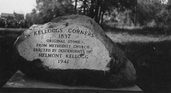 An original stone from the Methodist Episcopal Church built by Austin Kellogg around 1837. The text reads: "Kelloggs Corners 1837 Original Stone from Methodist Church Erected by Descendents of Helmont Kellogg 1941".