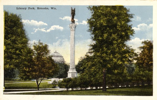 View of park with monument on lawn. A domed building is in the background. Caption reads: "Library Park, Kenosha, Wis."