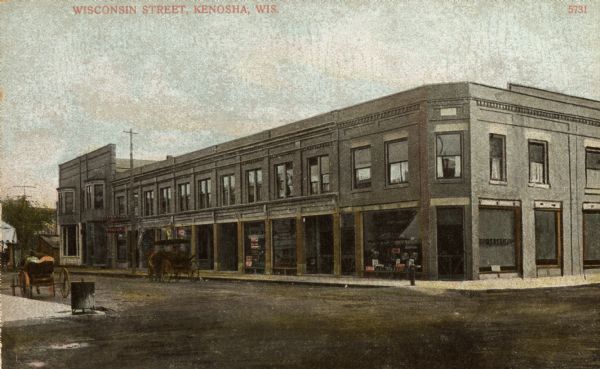 View across intersection toward a building on the street corner. Caption reads: "Wisconsin Street, Kenosha, Wis."