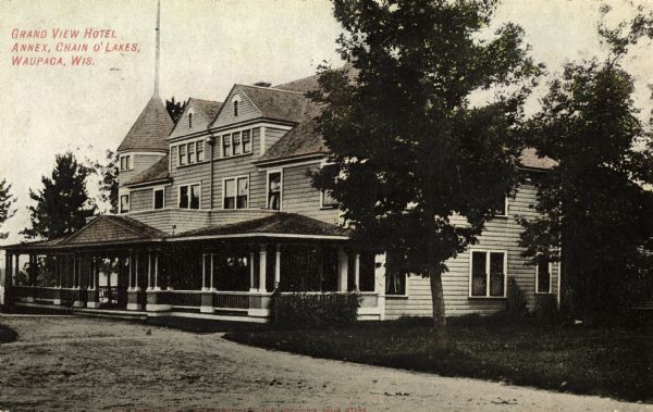 View across unpaved road towards the hotel. Caption reads: "Grand View Hotal Annex, Chain O'Lakes, Waupaca, Wis."