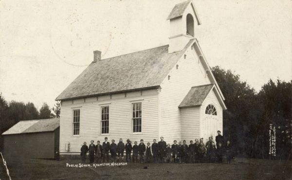 Exterior view of the school, with a young class and teacher posing in front. Caption reads: "Public School, Knowlton, Wisconsin".
