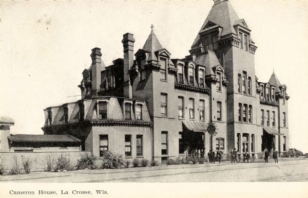 View across street toward the Cameron House. A group of people are near the entrance. Caption reads: "Cameron House, La Crosse, Wis."
