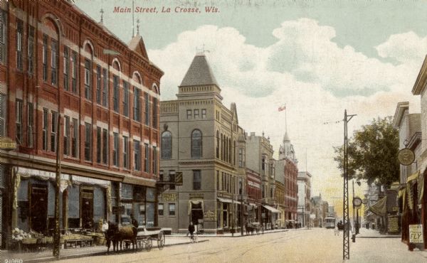 View along right side of street toward the left. Pedestrians and horse-drawn vehicles are along the sidewalks and curb. Caption reads: "Main Street, La Crosse, Wis."