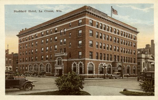 View across street toward the hotel. Caption reads: "Stoddard Hotel, La Crosse, Wis." Hotel Stoddard, "built by a company of wealthy citizens in response to a popular demand for a first-class hotel. It cost $240,000 and is one of the finest of the smaller hostelries of the northwest. The site...was purchased by popular subscription, costing $20,000 and was donated to the builders of the hotel."