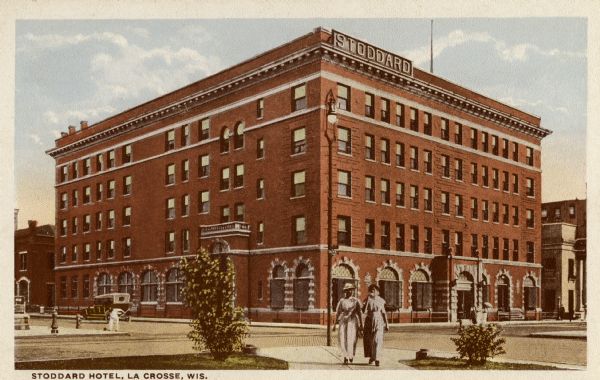 View from across intersection toward the hotel. Caption reads: "Stoddard Hotel, La Crosse, Wis." Hotel Stoddard, "built by a company of wealthy citizens in response to a popular demand for a first-class hotel. It cost $240,000 and is one of the finest of the smaller hostelries of the northwest. The site...was purchased by popular subscription, costing $20,000 and was donated to the builders of the hotel."