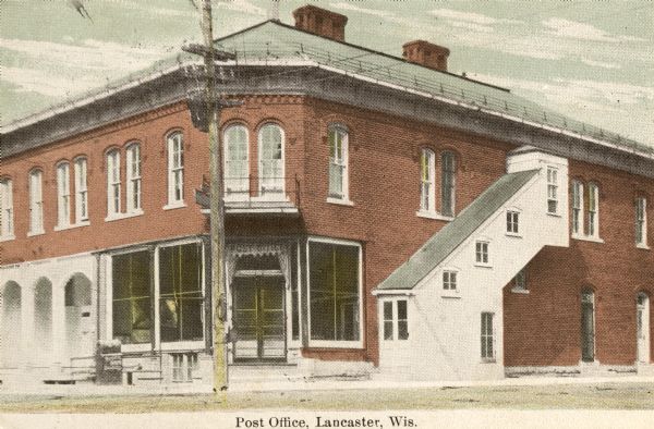 Exterior view of post office on a street corner. Caption reads: "Post Office, Lancaster, Wis."