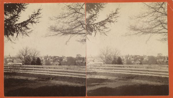 Stereograph of Lancaster from behind a wooden fence.