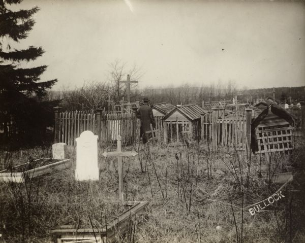 Burial grounds in La Pointe. A man is standing in the center with his back turned to the camera.