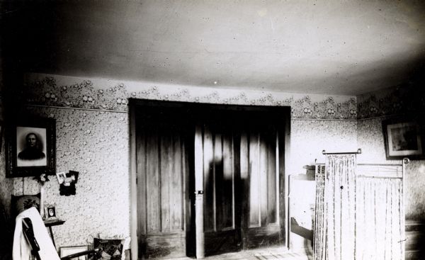 Interior of the Territorial Supreme Court building of the Wisconsin Territory (embracing present Iowa and Minnesota) built in 1836 of lumber brought by water from Pittsburgh, Pennsylvania. The building was constructed for use as the Supreme Court, but was never actually used. The only session of the Court at Leslie, was held in 1836 in the Legislative building, while the court was under construction, and was quickly adjourned for lack of business. The Court was soon thereafter moved to Burlington, Iowa, and then to Madison, Wisconsin. The building was later used as a horse barn on the Charles C. Arthur farm and later as the residence of Charles Dunn. It was eventually moved to a new foundation beside the restored Territorial Capitol and itself completely restored. 
Interior view showing double doors.