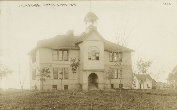 View across lawn toward the school. Caption reads: "High school, Little Chute, Wis."