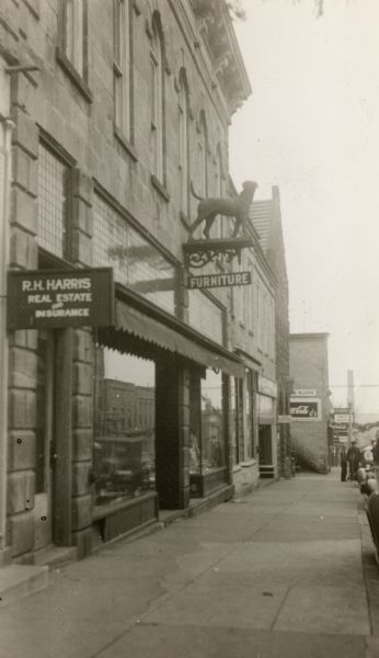 The Gundry, Gray and Company Furniture Store, with a scuplture of a dog mounted on the store sign.
