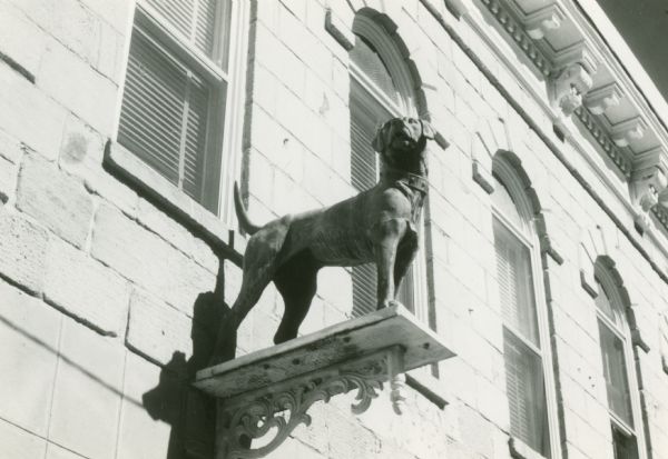 View looking up at the dog statue on the front of the Gundry, Gray and Company Store.