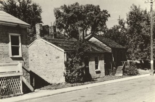 Cornish miner homes on Shake Rag Street. The home at the right, which has since been demolished, was constructed of clay mixed with marsh grass, pressed into woven willow branches, and covered with clapboards.