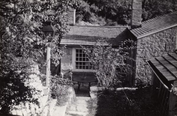 The patio and backyard area at the Cornish miner's cottage on Shake Rag Street called Trelawny. The cottage was restored under the ownership of Robert M. Neal and is now used to serve Cornish meals to guests by special reservation.
